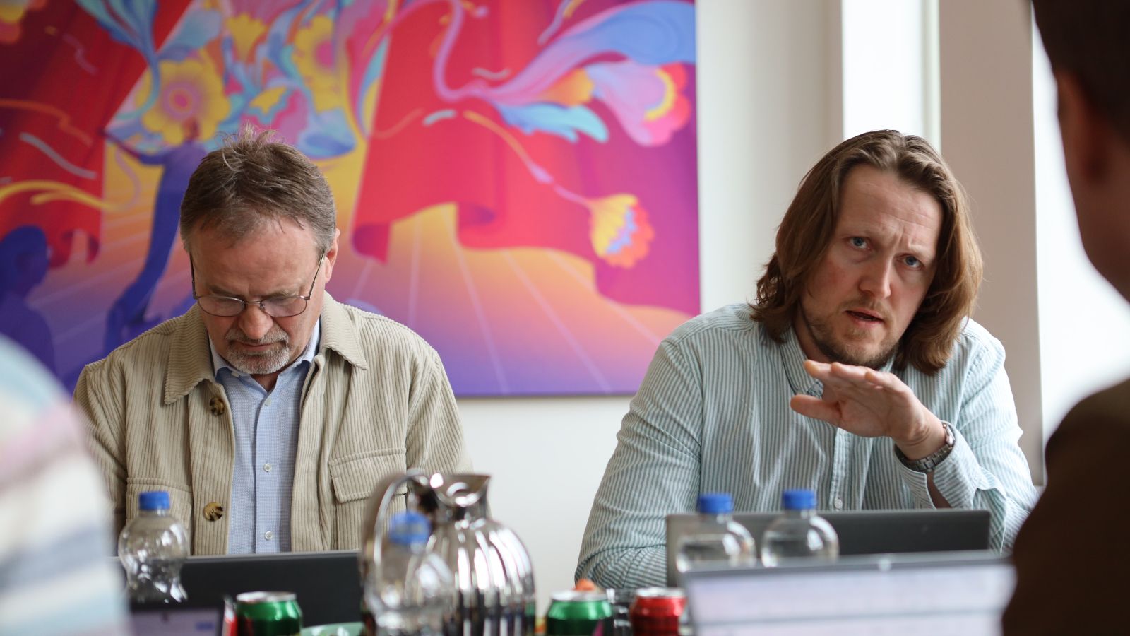 Gordon &Oslash;rskov og Morten Refskov ved hver sin computer. I baggrunden farvestr&aring;lende billede