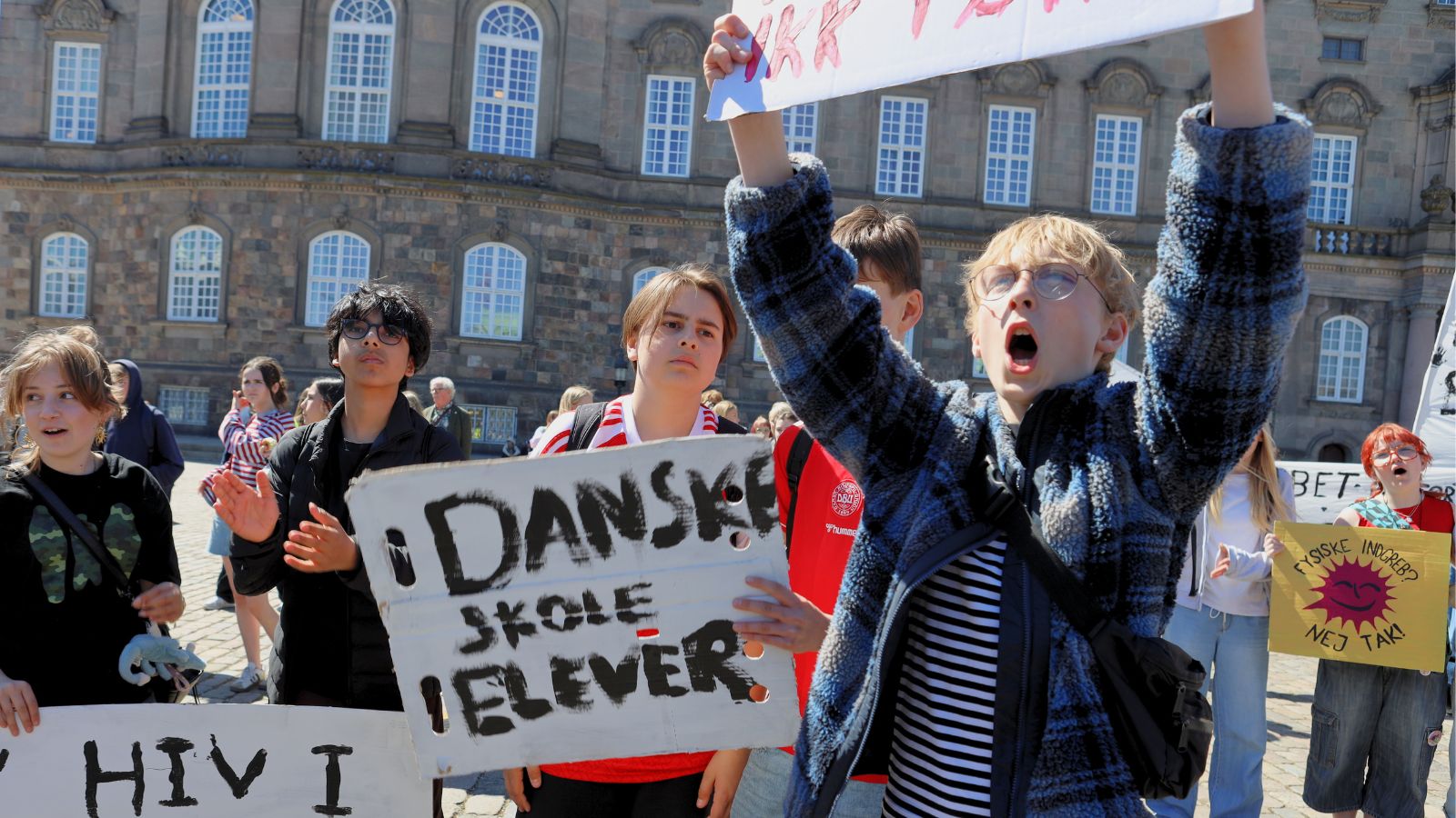 En flok elever med bannere foran scenen til demonstration p&aring; Christiansborg Slotsplads