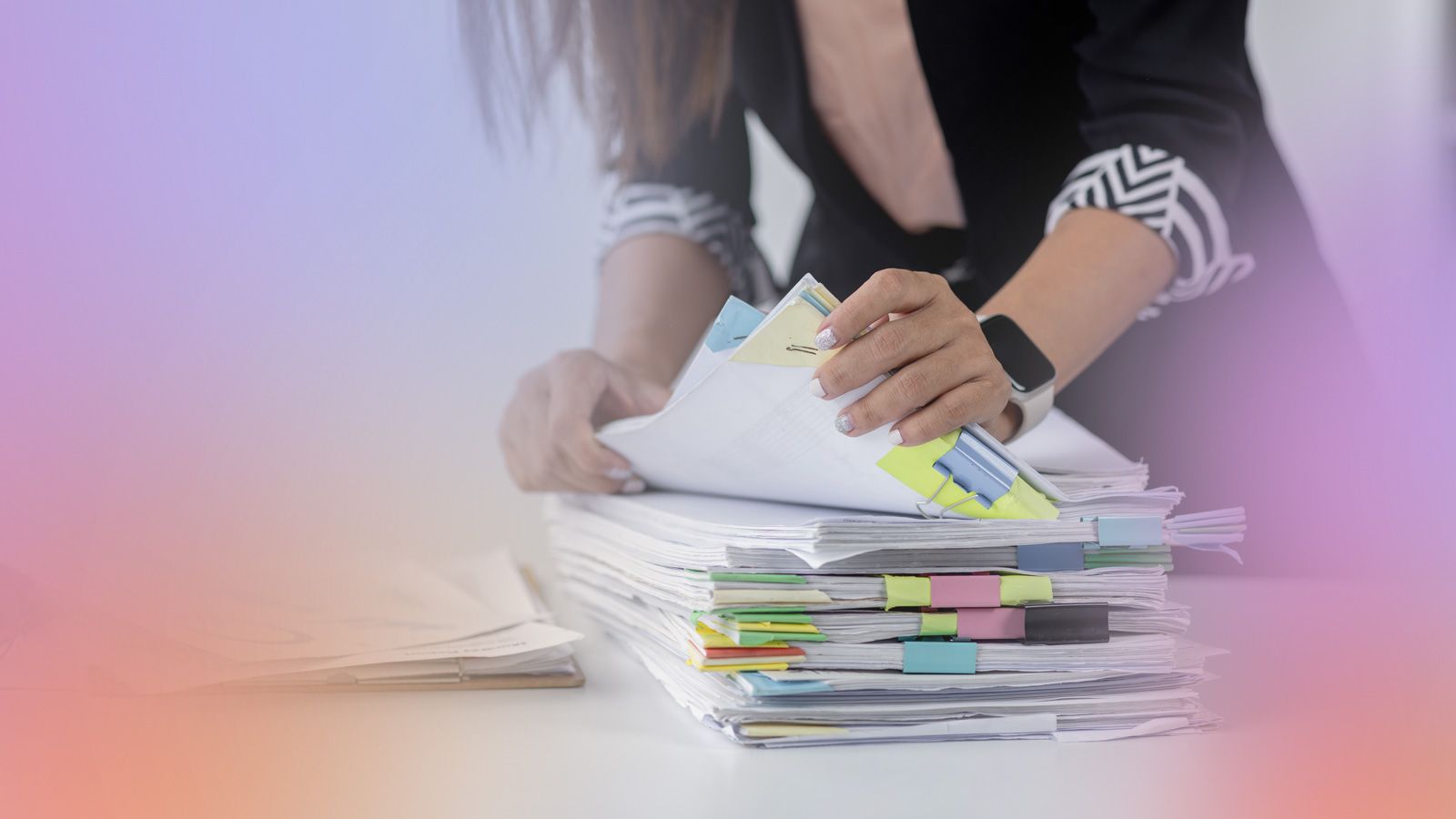 Lærer roder i sinepapirer på skrivebord.