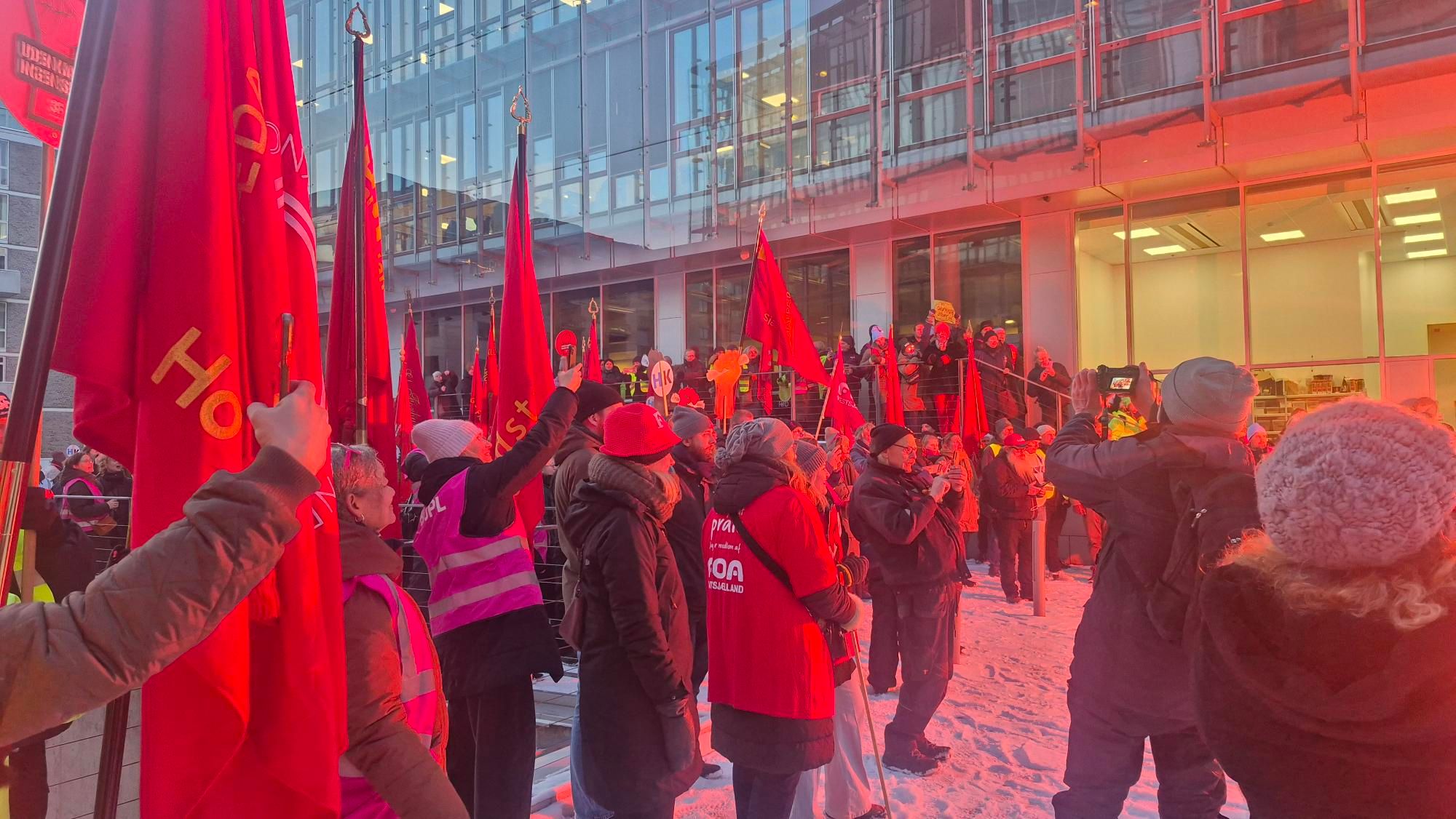 R&oslash;de faner, fagforeningsfolk og sne foran KL-Huset
