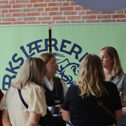 Gruppe af lærerstuderende samlet foran banner med Danmarks Lærerforenings logo