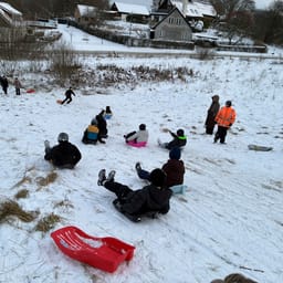 Elever i 5. klasse kælker ned ad en bakke