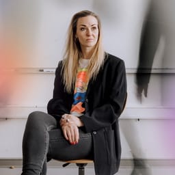 I et symbolsk billede sidder lærer Pernille Høy i et klasselokale omgivet af sin egen travle skikkelse.