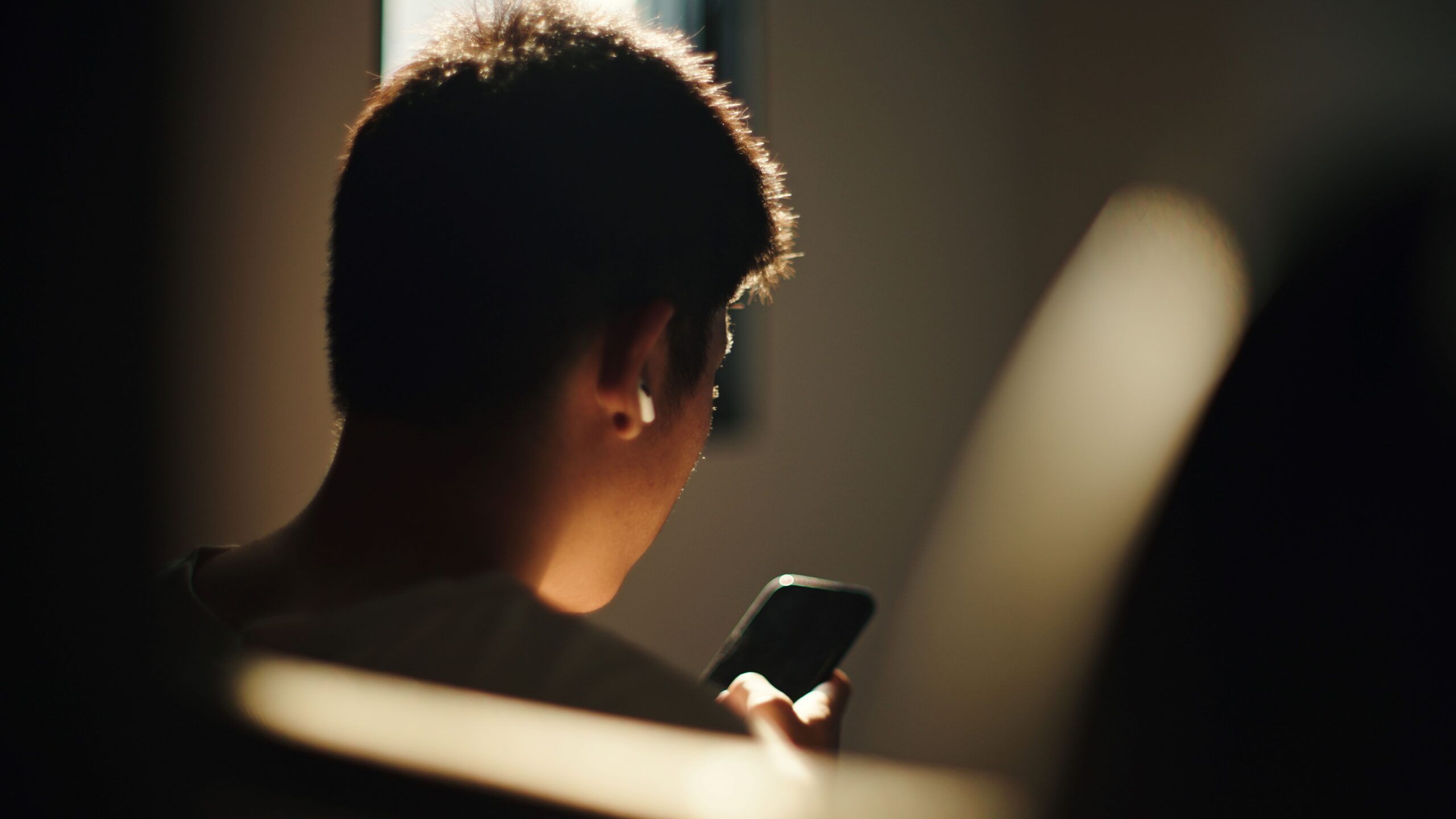 Teenagedreng kigger på sin telefon
