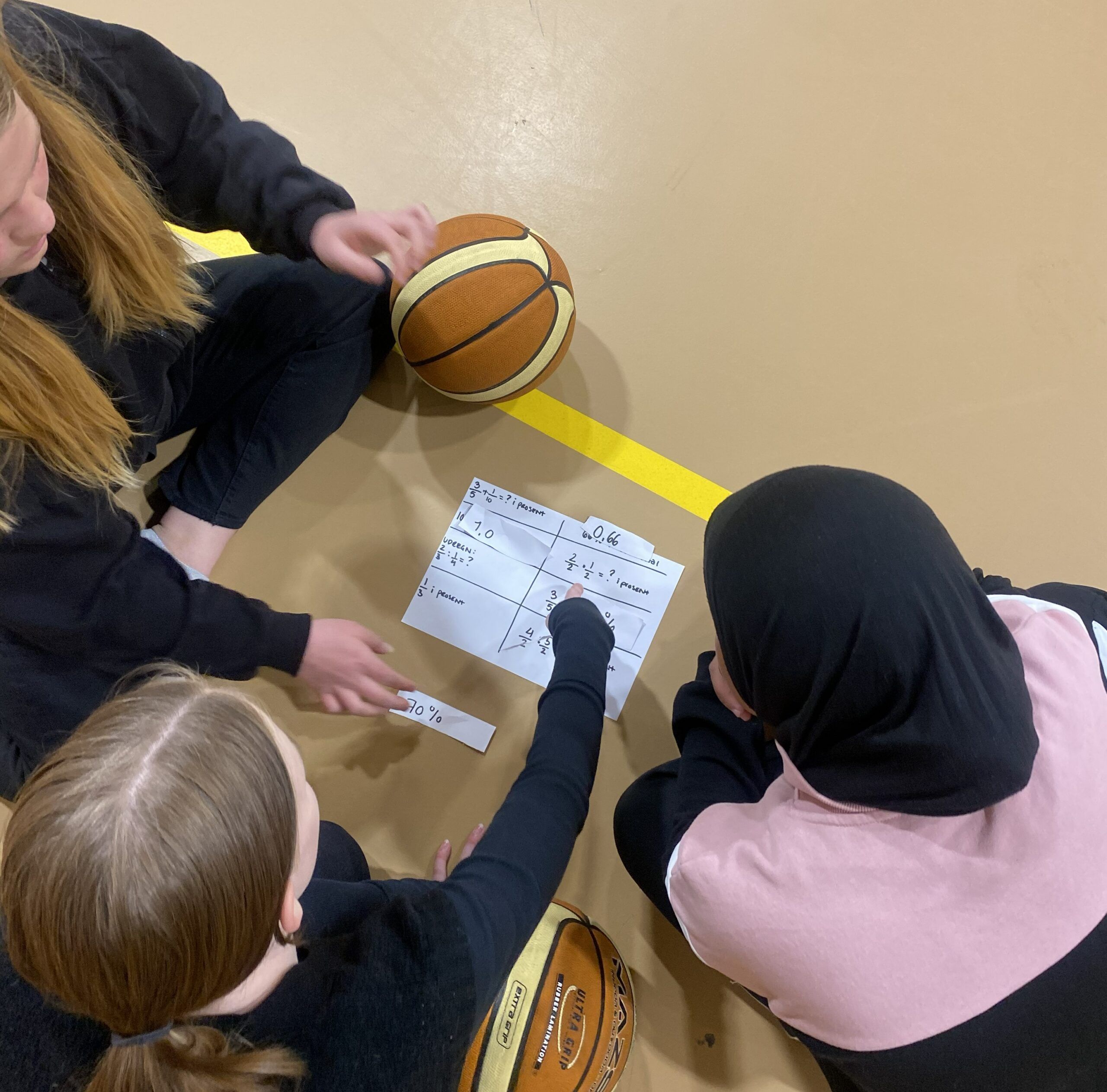 Tre elever l&oslash;ser br&oslash;kopgaver p&aring; halgulv.