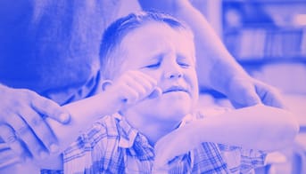 voksen holder lille vred drengs fast i armene