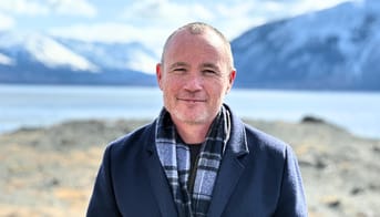 Portrætbillede af Pilo Samuelsen foran bjerge i Grønland