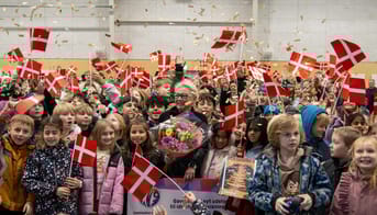 Inge Dinis Jensen omringet af elever med flag