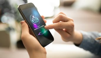 Modelfoto af barnehånd, der bruger AI-funktion på en smartphone