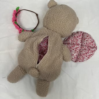 Billede af en bamse syet i H&D undervisningen. På billedet ses bamsen bagfra, så man kan se lynlås detaljerne.