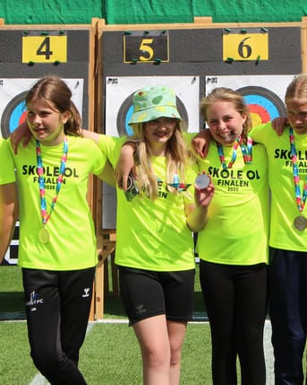 Elever i gule trøjer fejrer at have vundet medalje til finalen i Skole-OL