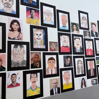 Billede af karikaturportrætterne, der hænger på en væg.