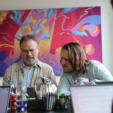 Gordon Ørskov og Morten Refskov diskuterer noget, de ser på en computer