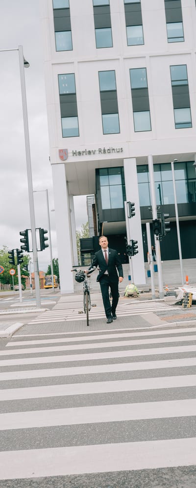 Billede af Marco Damsgaard der er i gang med at krydse et lyskrydse med sin cykel i hånden.