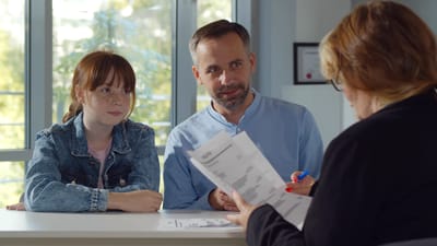 Forældremøde med far, datter og en lærer