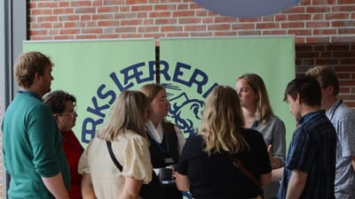 Gruppe af lærerstuderende samlet foran banner med Danmarks Lærerforenings logo