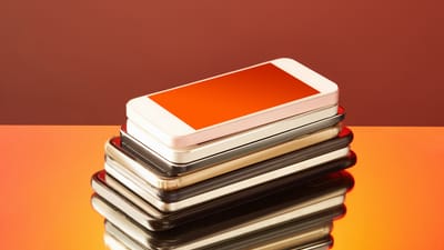 En stak forskellige smartphones i en stabel på et bord