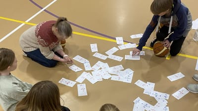 Lærer og elever løser brøkopgaver på et halgulv