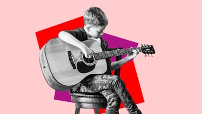 Dreng i 4. eller 5. klasse spiller guitar med benene over kors.