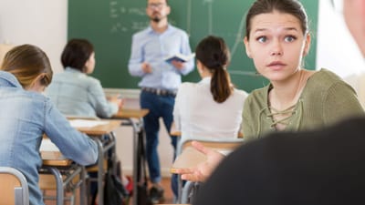 pige spørger kammerat om hjælp i undervisningen