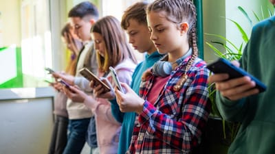 6.-7.-klasseelever kigger i deres telefon på skolegang