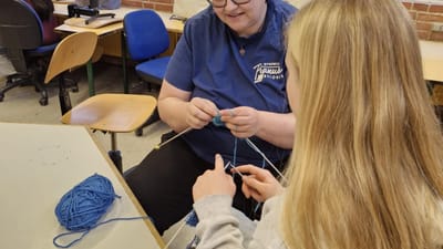 Christina Nissen lærer elev at strikke