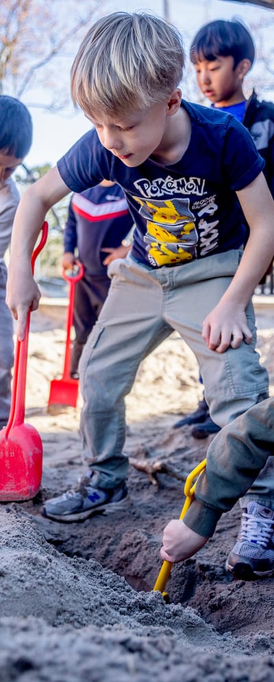 Billede af 0.klasse elever der leger i en sandkasse.