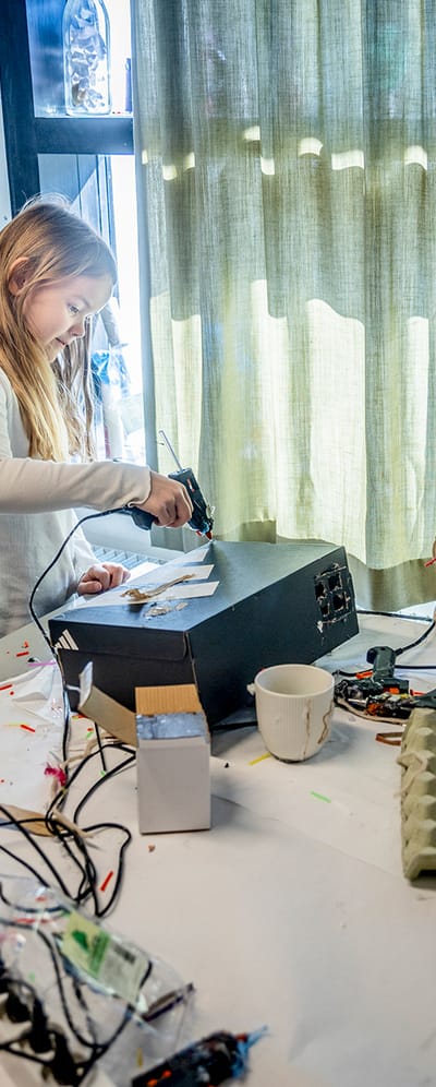 Billede af fire elever der står rundt om et bord