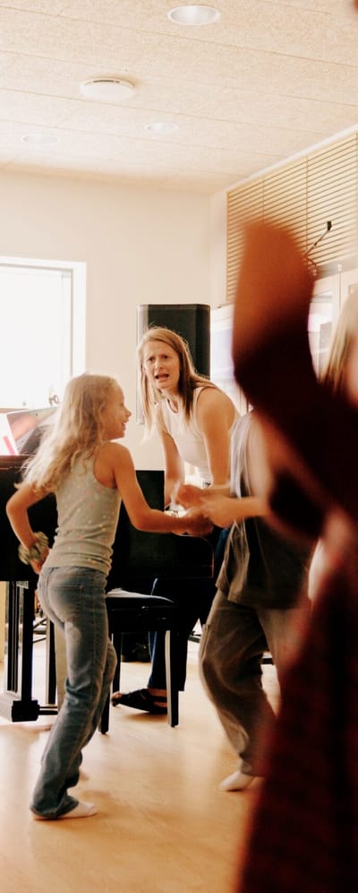 Elever og forældre der danser og synger