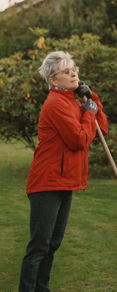 Billede af Lone, der står i sin have med lukkede øjne